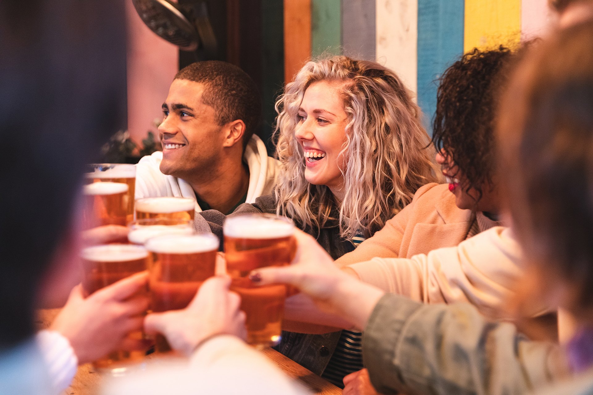 Group of young adults clinking glasses together