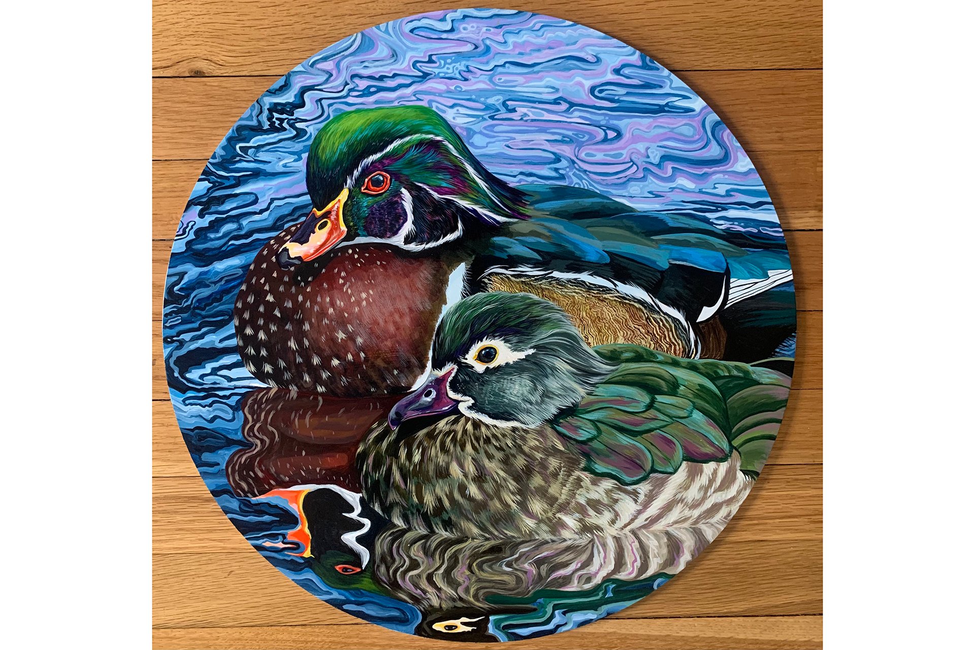 A painting on round canvas of two Wood ducks