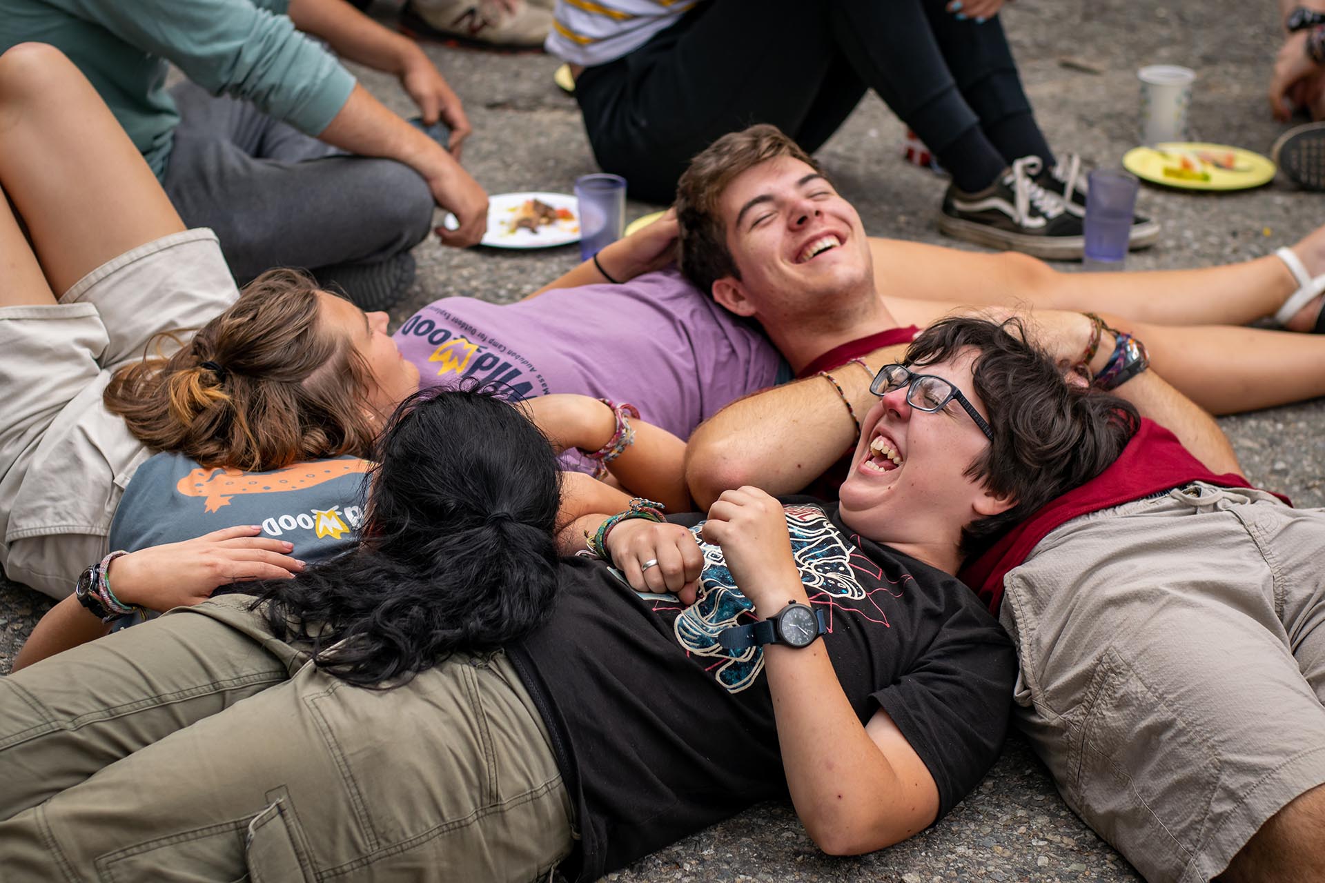 four people laying on their backs with their heads resting on their stomach, forming a square.