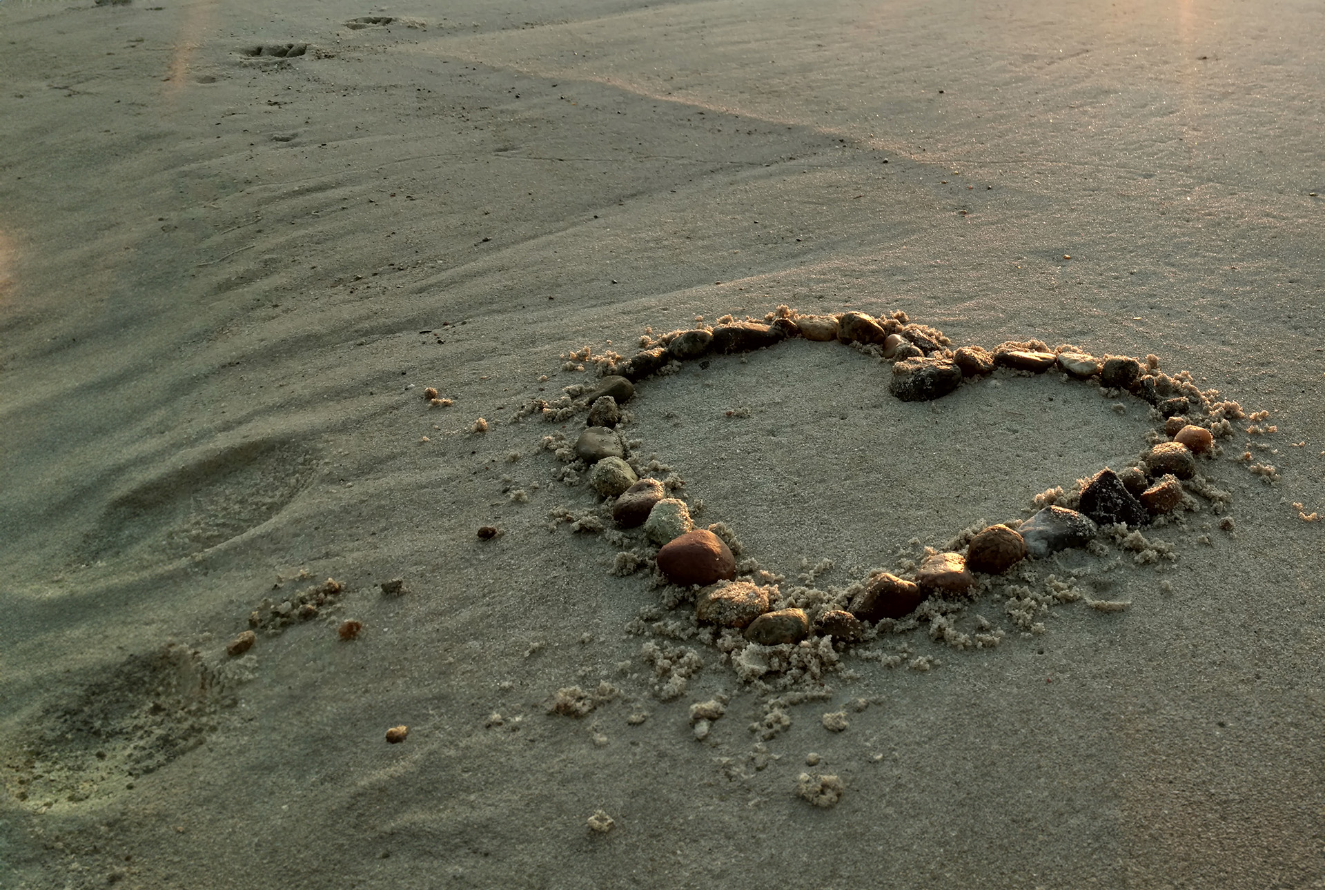Heart made of rocks in the sand