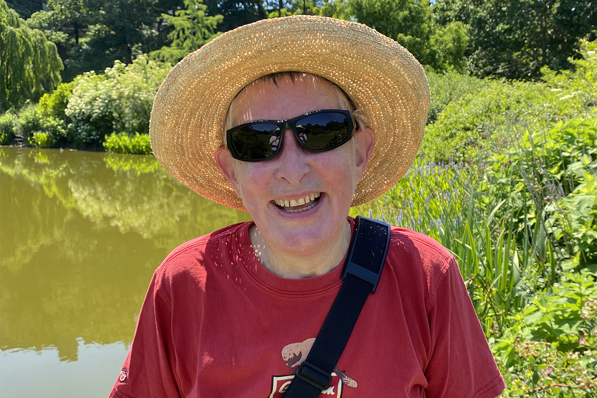 Person smiling in a sun hat and sunglasses.