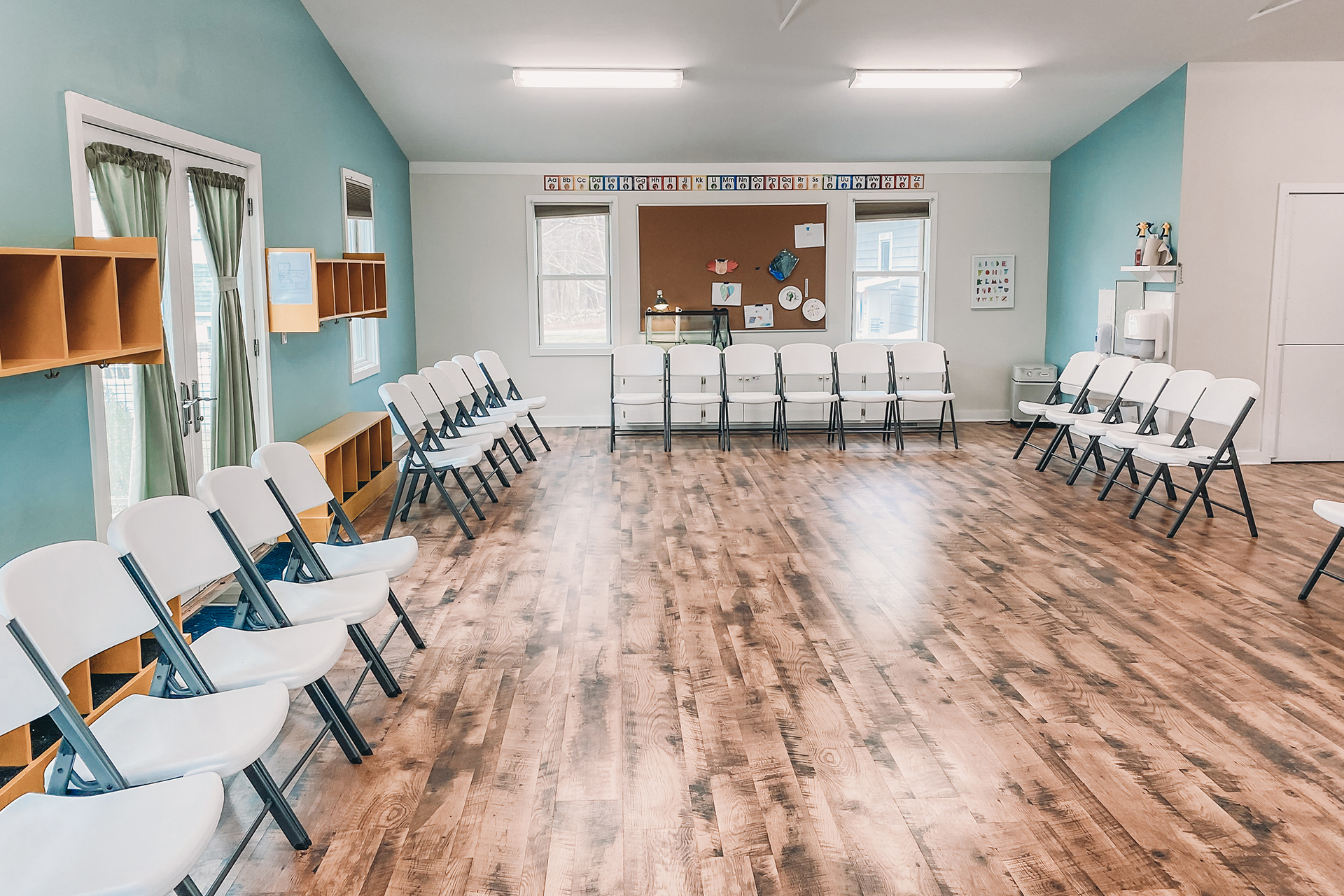 Auditorium set up to accommodate chairs around its perimiter, viewed from one end of the room