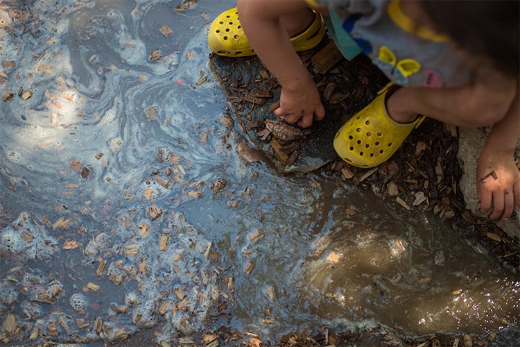 Small child playing in a puddle of water