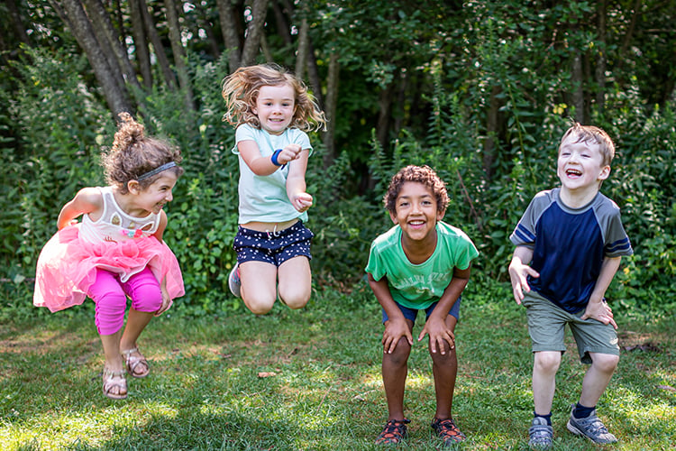 Four small kids jumping & laughing at Arcadia Wildlife Sanctuary © Phil Doyle