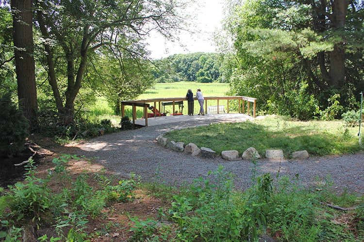 Two people enjoying the view from the All Persons Trail overlook at Broadmoor Wildlife Sanctuary