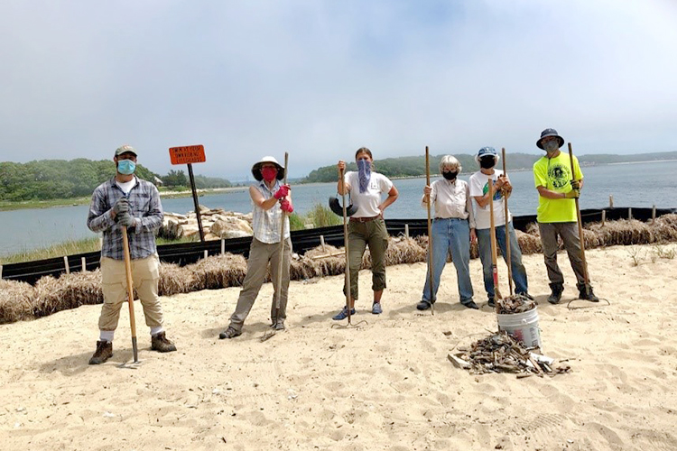 A group of volunteers clearing debris from the beach at Great Neck Wildlife Sanctuary following the removal of the boathouse.
