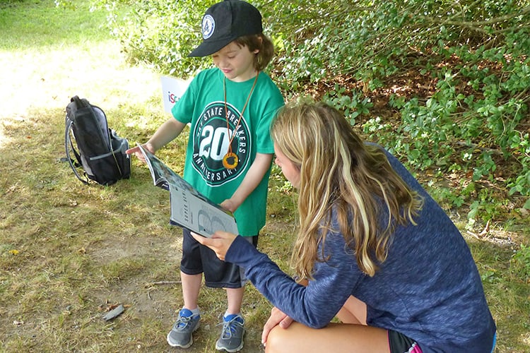 NR counselor and camper using field guide